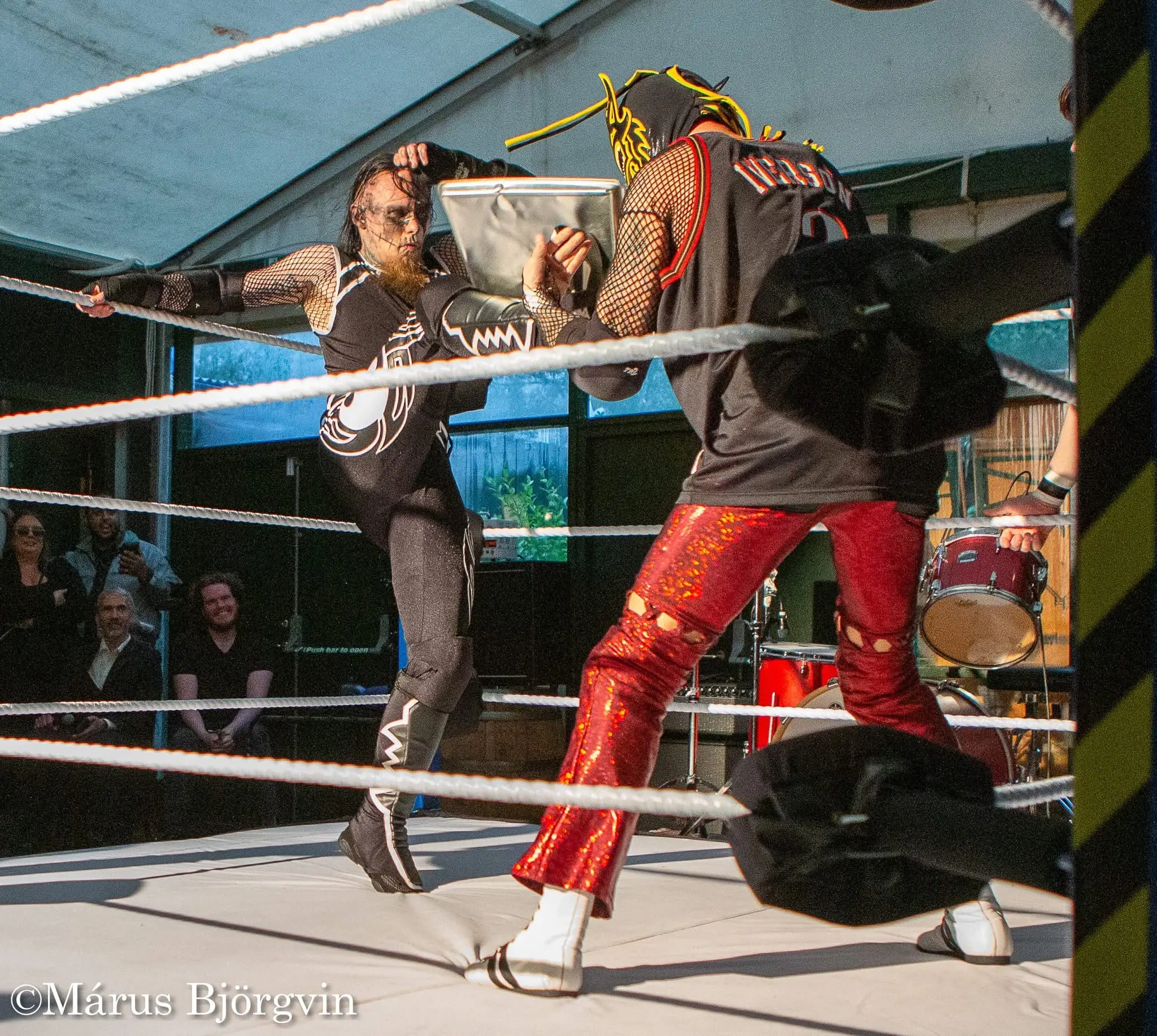 A wrestler standing in the middle of the ring with a microphone, addressing the crowd