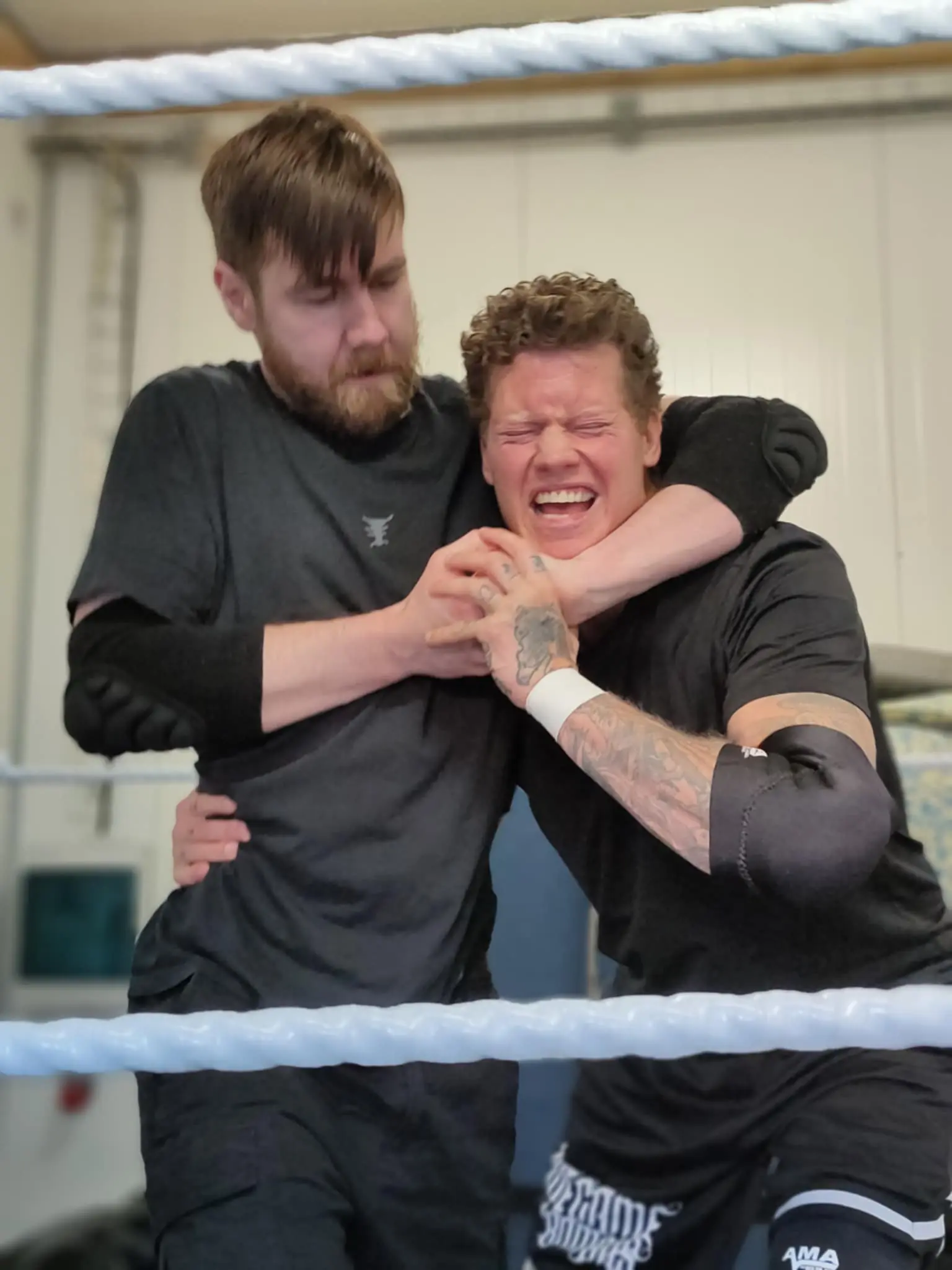 A wrestler being headlocked by another wrestler in the ring
